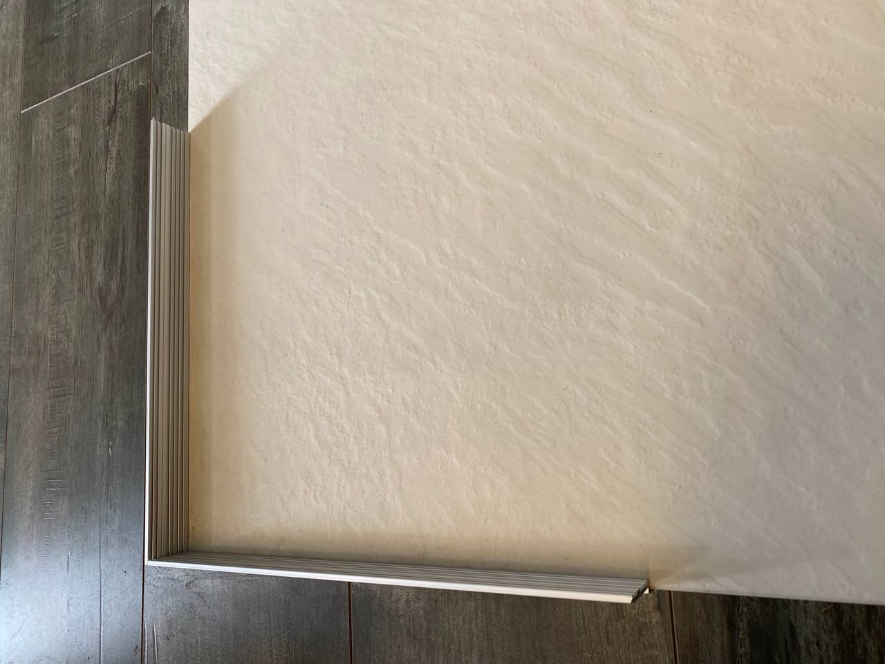 SMC slate shower base ribbed front threshold detail with dark tile flooring